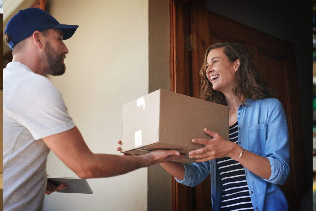 Delivery man handing woman parcel